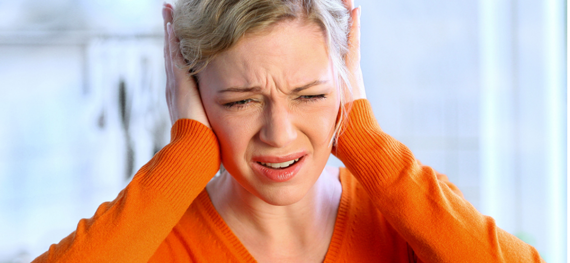 osoba koja drži uvo zbog zujanja u ušima